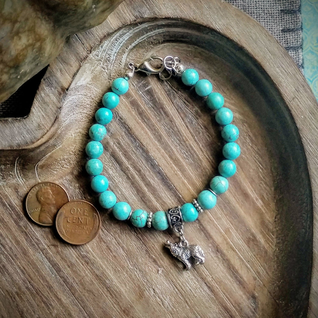 Beautiful turquoise magnesite beaded bracelet with a tiny detailed pewter howling wolf.  